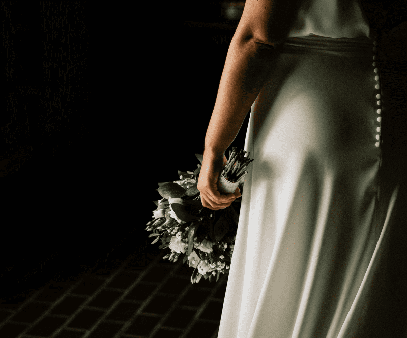 fotografia tenue de una novia agarrando el ramo
