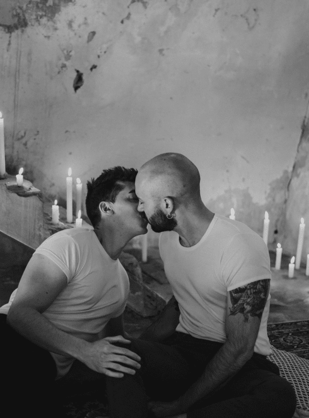 fotografia en blanco y negro de una pareja dandose un beso a la luz de las velas
