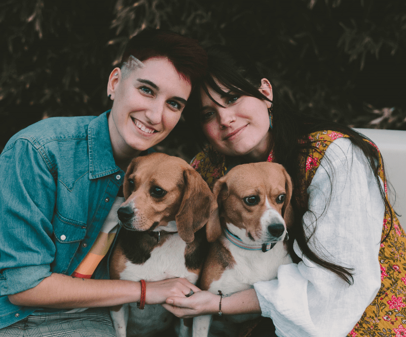 fotografia de una pareja y sus dos perros en el parque