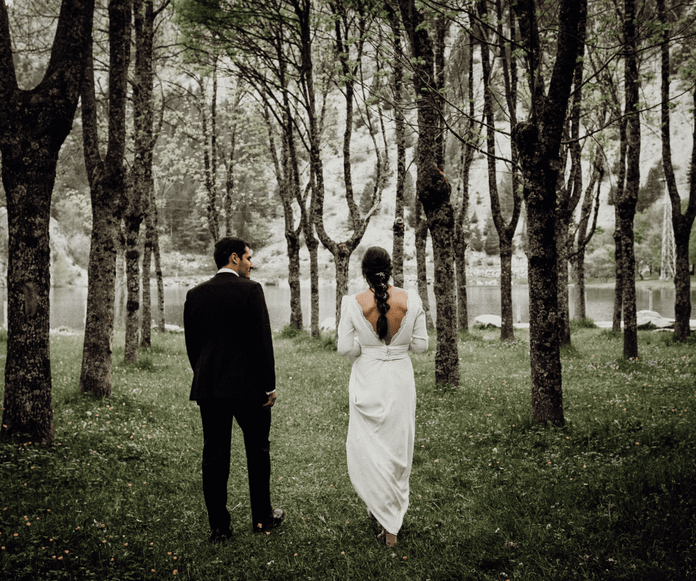fotografia de una pareja vestida de novios en el bosque